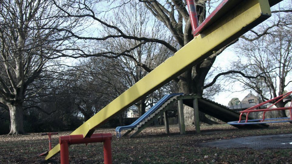 A yellow seesaw tilted with one end high in the air