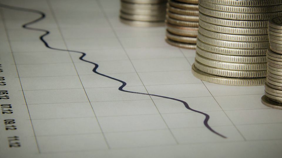 Coin stacks beside a line chart drawn on graph paper
