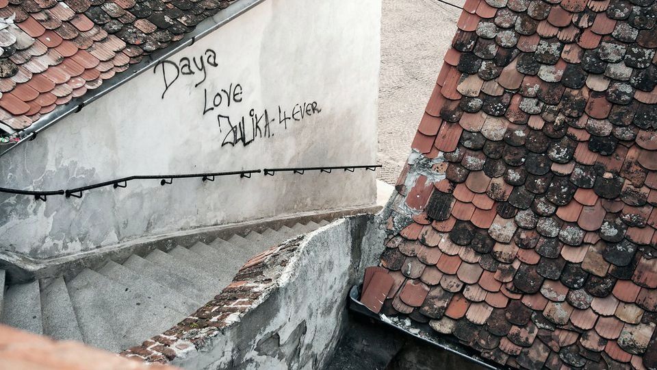 Narrow stone stairs descending between tiled rooftops