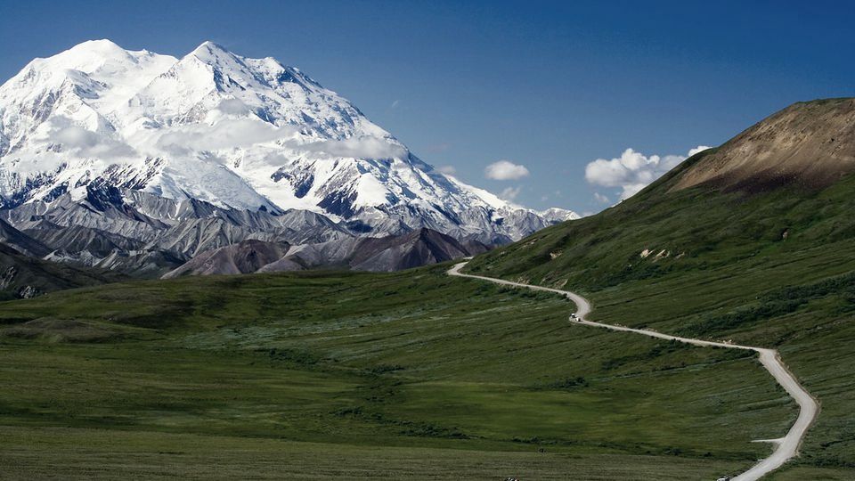Snow-capped mountain peaks above a valley trail