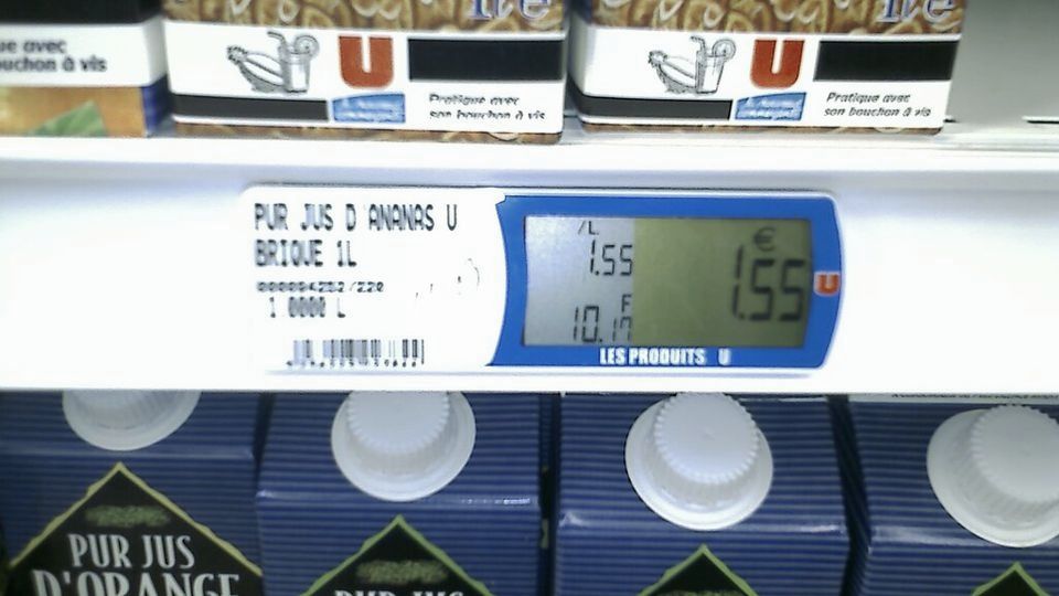 Electronic shelf price label above cartons of juice