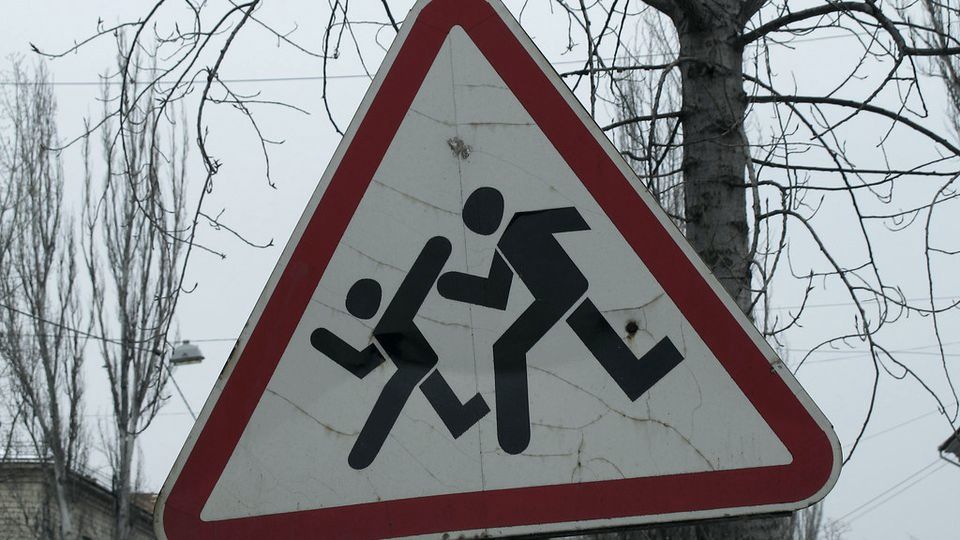 A triangular red-and-white warning road sign