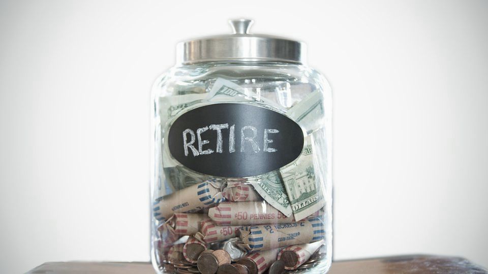 A glass jar labeled 'Retire' stuffed with banknotes