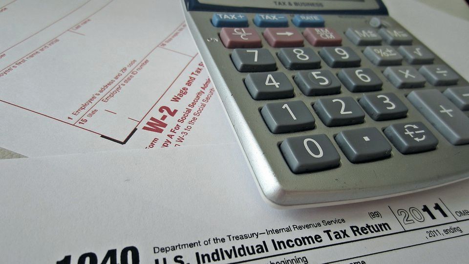 U.S. Form 1040 tax return with a calculator on top