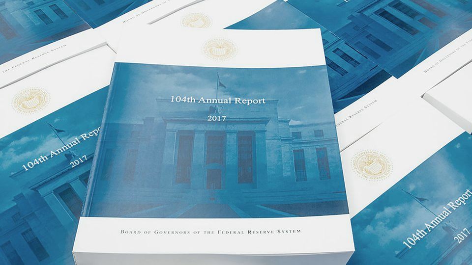 Printed copies of an annual report spread across a table